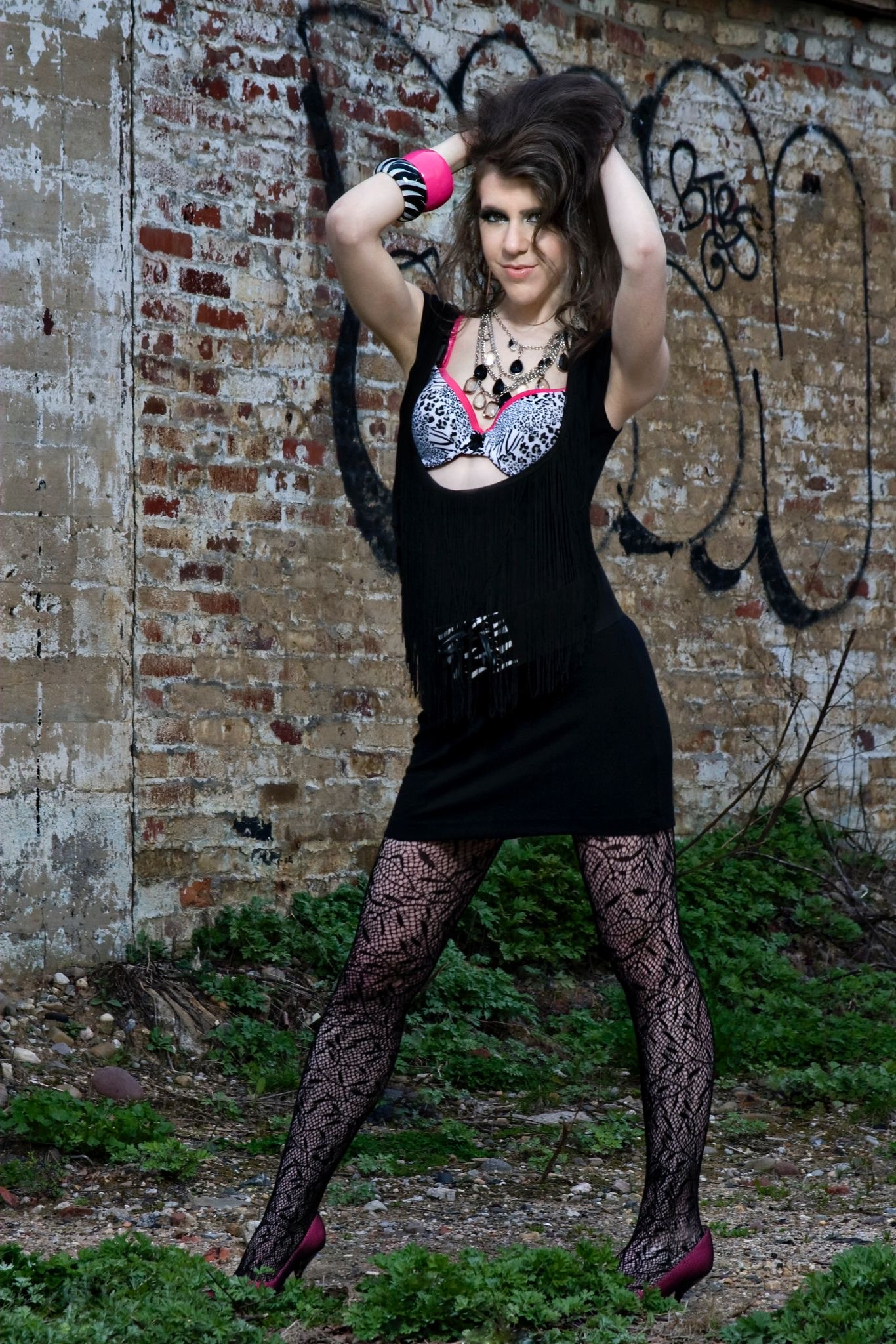 Kimberly Korn photographed against a weathered brick wall.